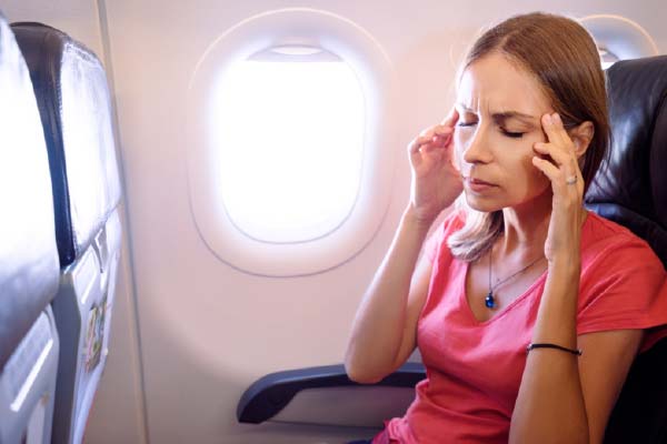 Woman on Plane Touching Temples