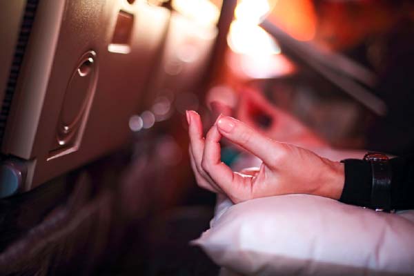 Womans Hands Resting on Plane Seat Pillow