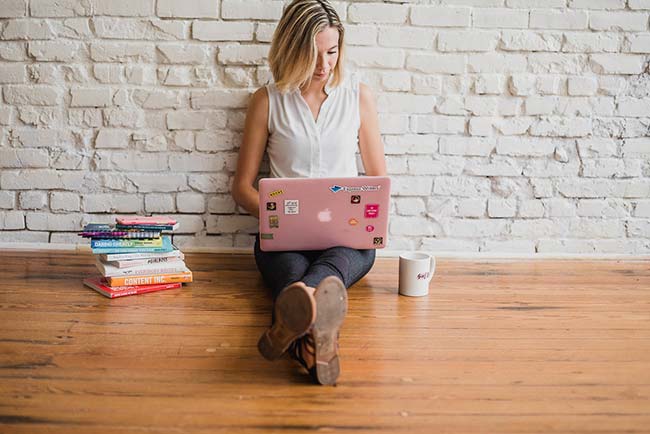 Blonde Woman Sat on Floor Using Laptop