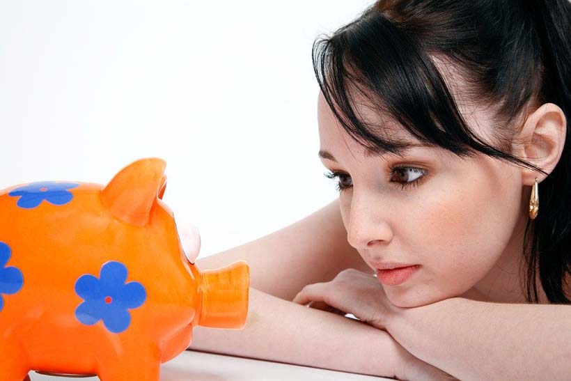 Girl Looking at Piggy Bank