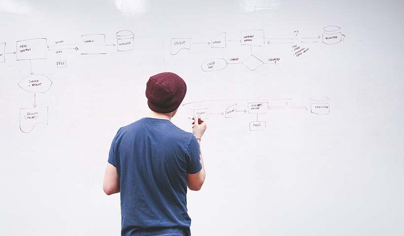 Young Professional Writing on Whiteboard