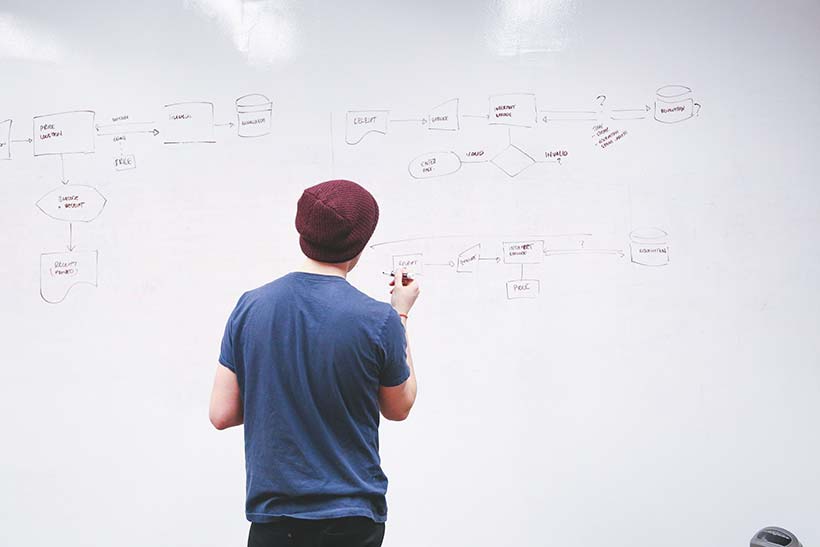 Young Professional Writing on Whiteboard